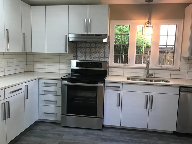Brand new custom cabinets with designer tile and quartz countertops.