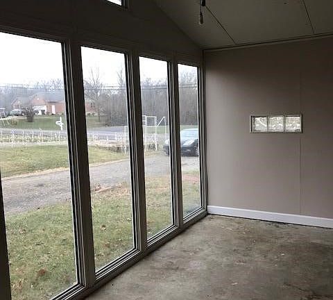 Sunroom/Study with concrete floor multiple large windows
