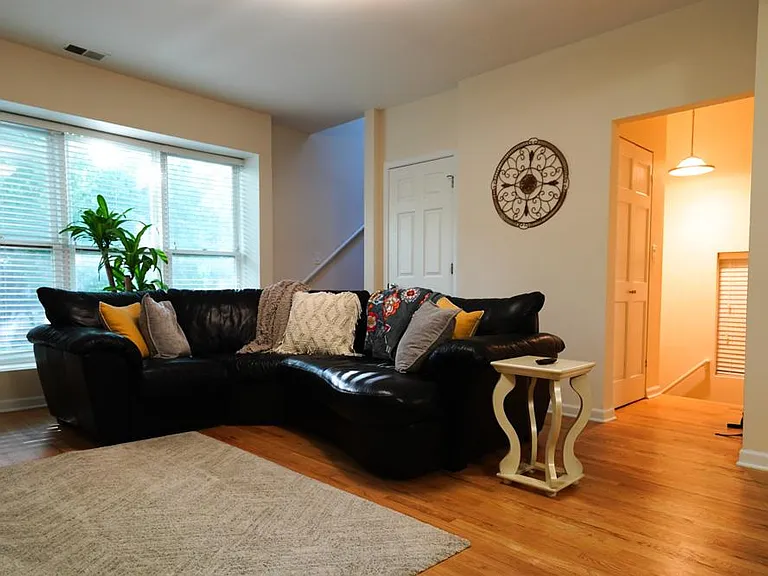 Living area; windows facing west to Southport. Staircase upstairs on the left, staircase to front door on the right