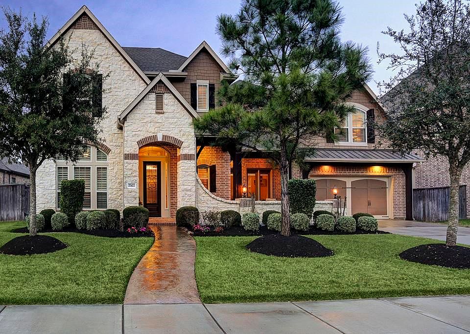 Great curb appeal on a cul-de-sac  street featuring brick and stone elevation and lush landscaping