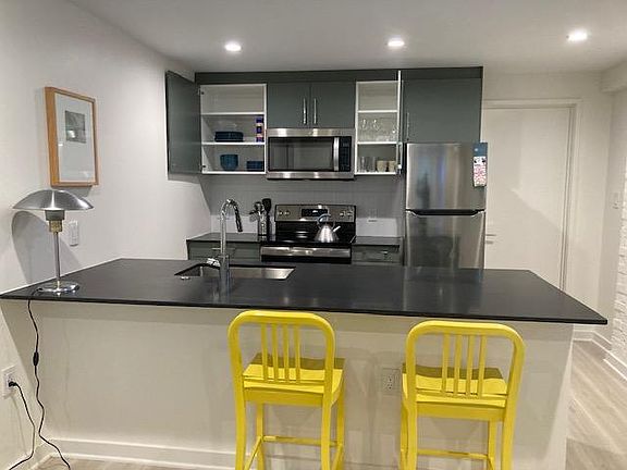 Kitchen cabinets are stocked with plates, bowls, cups, glasses.