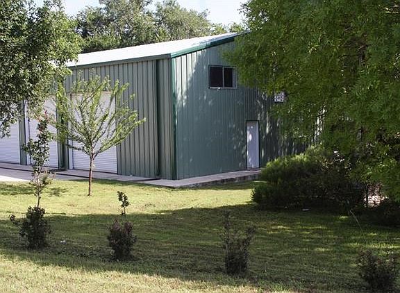 Huge garage with three bay doors, storage room, work shop, loft and hot tub in screened porch behind.