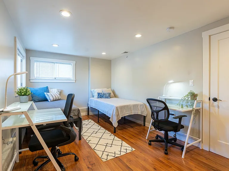 A spacious, naturally lit bedroom featuring sleek decor A spacious, naturally lit bedroom featuring sleek decor