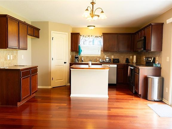 Warm wood flooring and classic dark cabinetry anchor this functional kitchen with sliding glass doors.