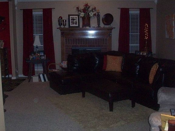 living area with fauxwood blinds, new paint and red brick fireplace