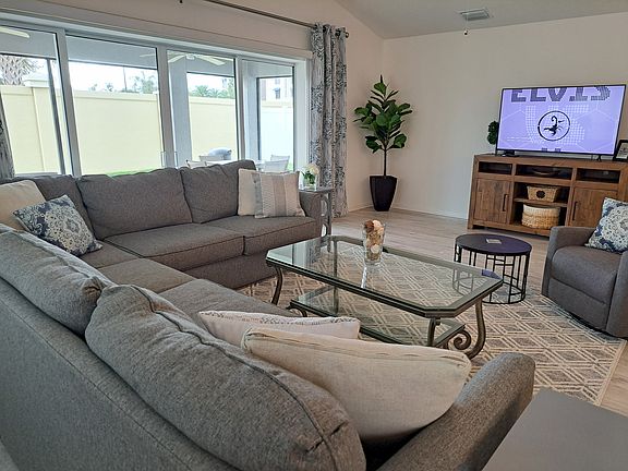 Living room with large gray sectional with large TV.