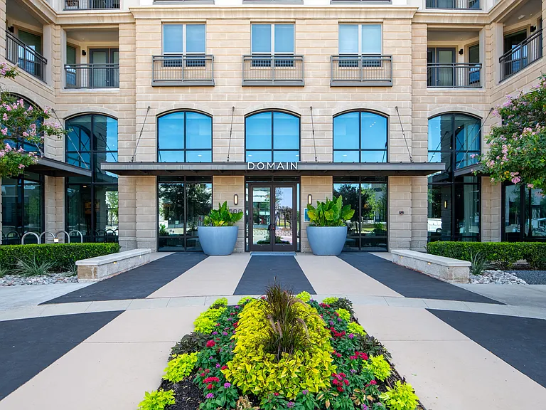 Domain at The Gate Entrance Framed by Flowers and Modern Architecture