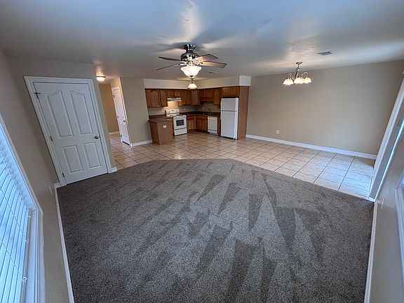Living and kitchen view. Storage area under stairs visible on the left.