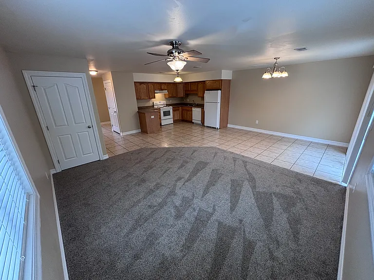 Living and kitchen view. Storage area under stairs visible on the left.
