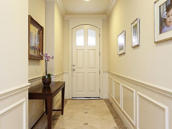 Classic Wainscoting and Travertine Tiled Entry.