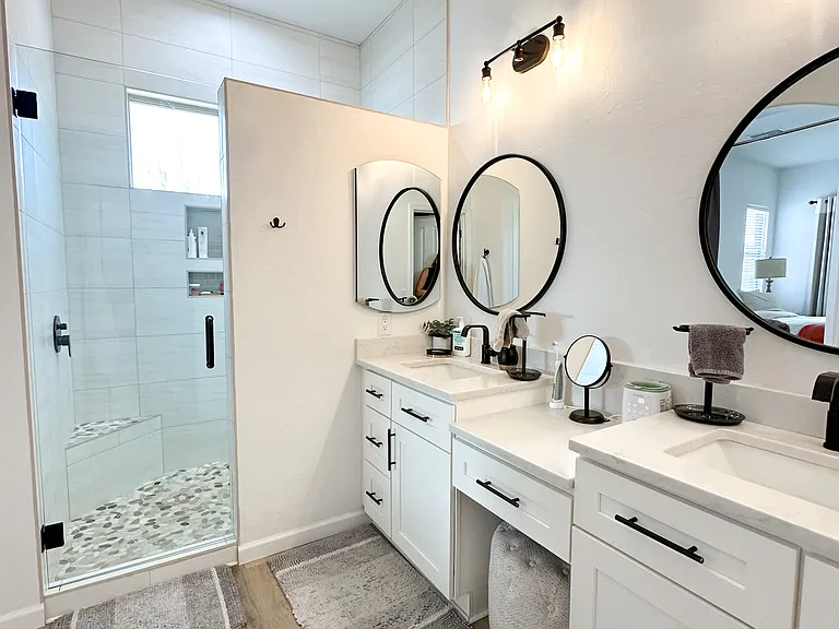 Remodeled double vanity master bath with walk in shower and storage.