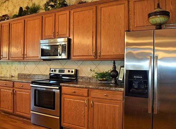 Updated kitchen with upgraded countertops, stainless steel appliances, 42" cabinets and tile backspl