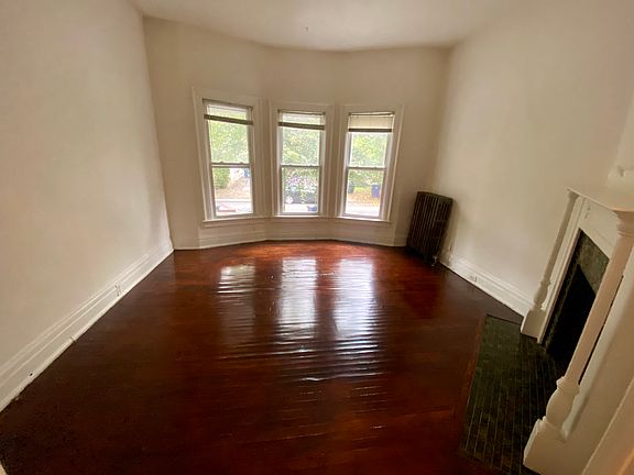 Living room fresh painted newly polyurethaned floor, fireplace. bay windows to front porch