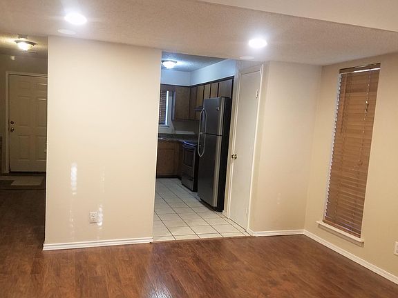Looking from the fireplace towards the front door and into the kitchen. Center area is where the half bath is and on the opposite end by the front door is a coat closet.