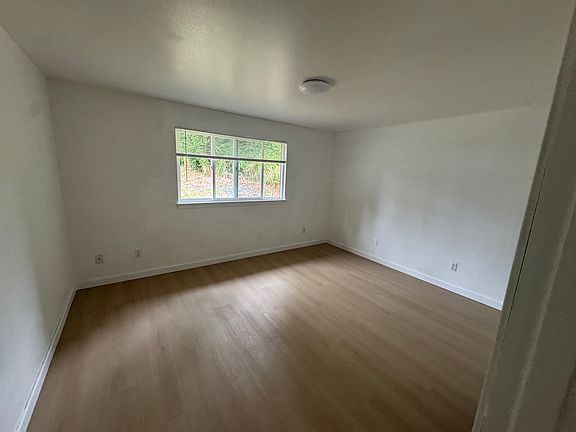 Bright secondary bedroom with new hard-surface flooring, a spacious closet, and abundant natural light.