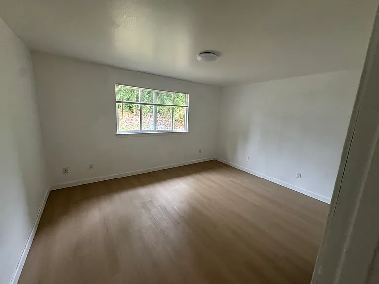 Bright secondary bedroom with new hard-surface flooring, a spacious closet, and abundant natural light.