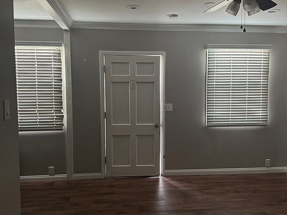 rear entry door to kitchen & dining area. Large space and closet (pantry) and bathroom access. Ceiling fan. Wall A/c unit. crown mouldings