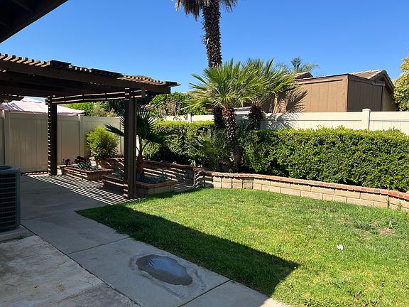 Private backyard with covered patio and grassy area