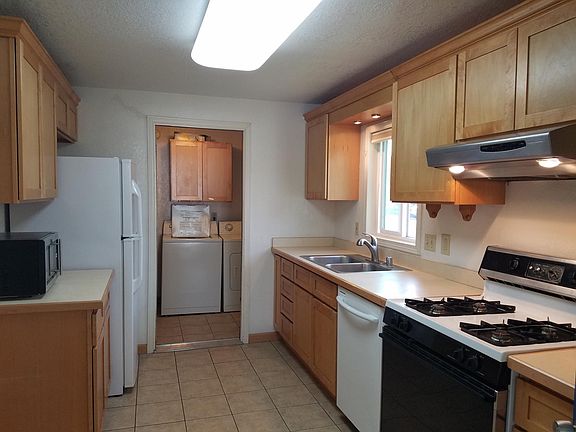 Sound canceling door separates full size laundry room from kitchen.