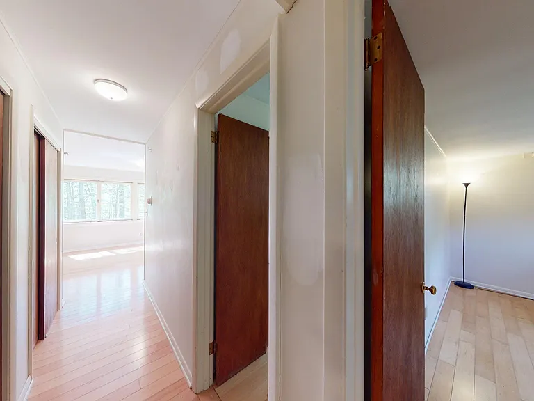 The main hall looking back toward the living room showing the bedrooms on the right and the 2 storage closets on the left.