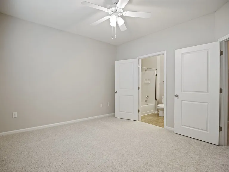 Bedroom with ceiling fan and lush carpeting