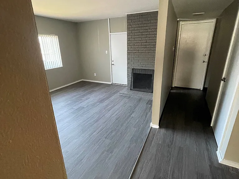 Upgraded living room and entry with luxury vinyl plank flooring, gray finishes and cozy fireplace