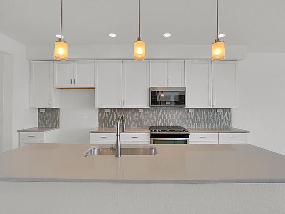Kitchen featuring large island. Photo representing home to be built and may demonstrate optional fe