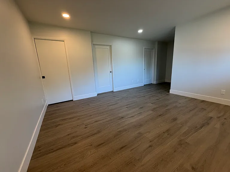 Primary Bedroom with doors to his and her section of primary bath and closet