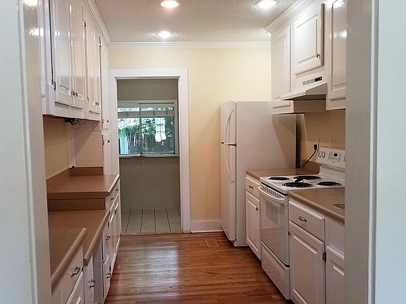 Galley Kitchen with electric stove, dishwasher, garbage disposal, fridge with icemaker. Laundry room and entry to garage at the end.