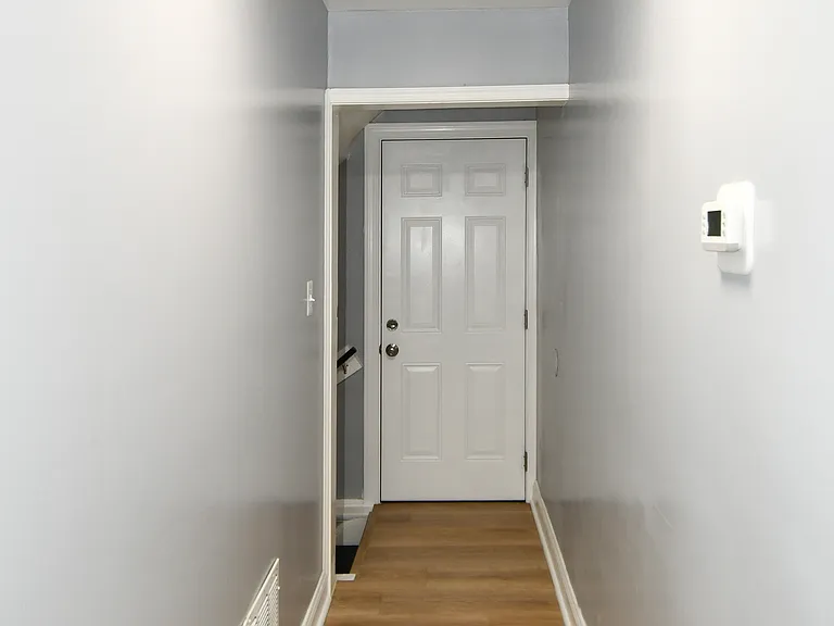 View of the side door, and stairs leading to the lower basement level.