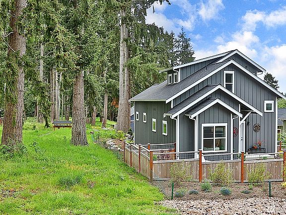The community lot with trail has some nice evergreens to enjoy.  This side of the house is fenced with a patio space.