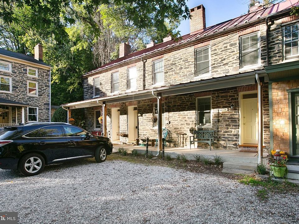 Picture shows row of 4 stone houses. The house that is available for rent is in front of the parked car.