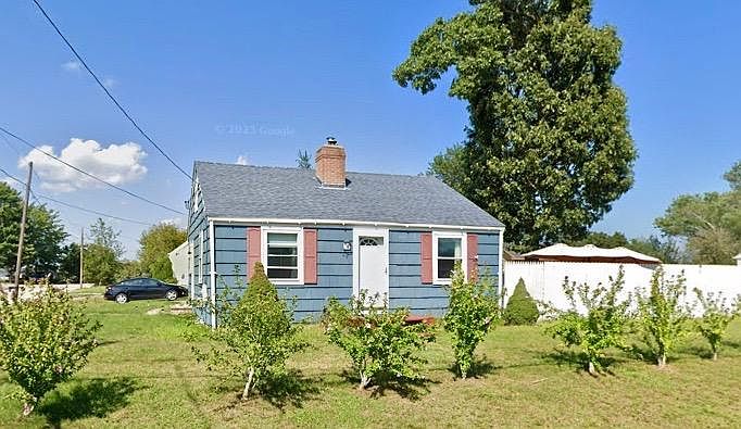 Rose of Sharons bloom in the summer. Along right of the house is the white fence of the back and side yard.