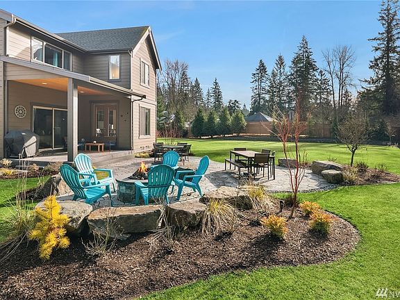 Covered patio has gas hook-up for your BBQ.  Recently added: Custom landscaping & lighting, boulders, gas line extended to fire pit on flagstone patio, additional trees, shrubs, seasonal blooms & sprinkler system.  Lots of sunlight in the back yard - room to relax, play & garden.
