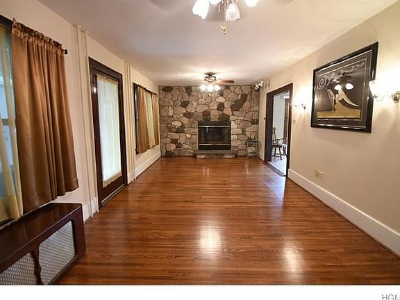 Large living room with hardwood flooring and stone fireplace.