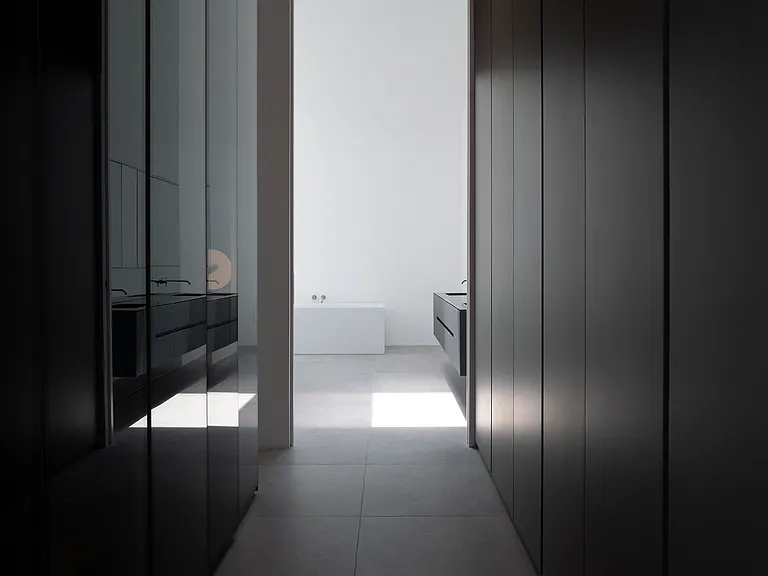 Expansive Dressing Room with Ambient Lighting and Custom Finishes _ A masterclass in understated luxury, this dressing room features floor-to-ceiling built-in cabinetry and soft, indirect lighting that flows into the primary bathroom.