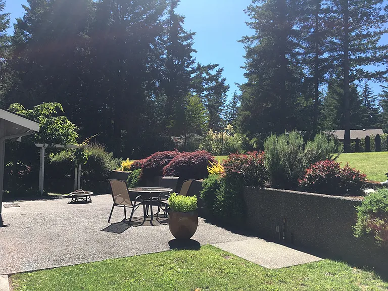 Backyard with built in fire pit area and gas hookup for barbecue.