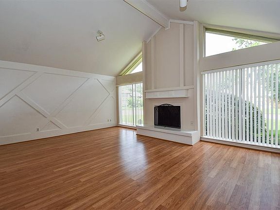 Large family room offers laminate wood flooring, high ceiling, recessed lights, custom fireplace and recent window coverings.