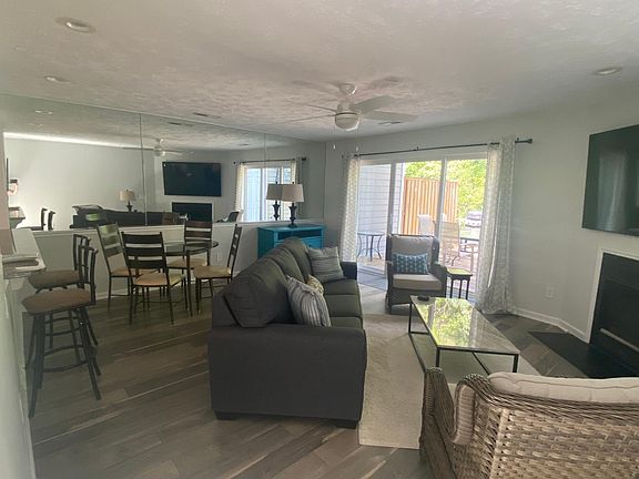 Large living room with new furniture, 75 inch Smart TV and table for 4 and bar seating