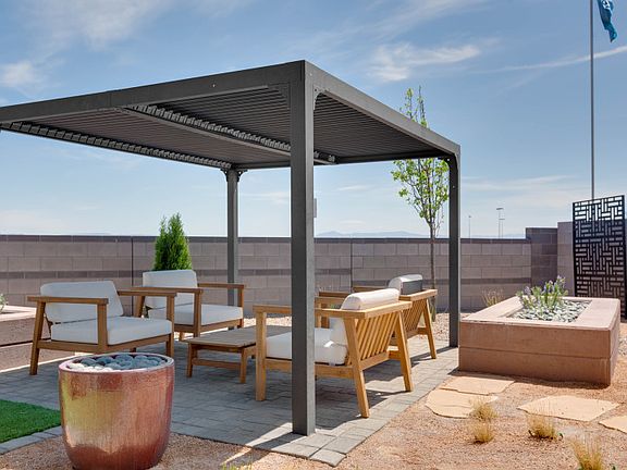 Backyard shown with a beautiful pergola perfect for relaxing on sunny days.