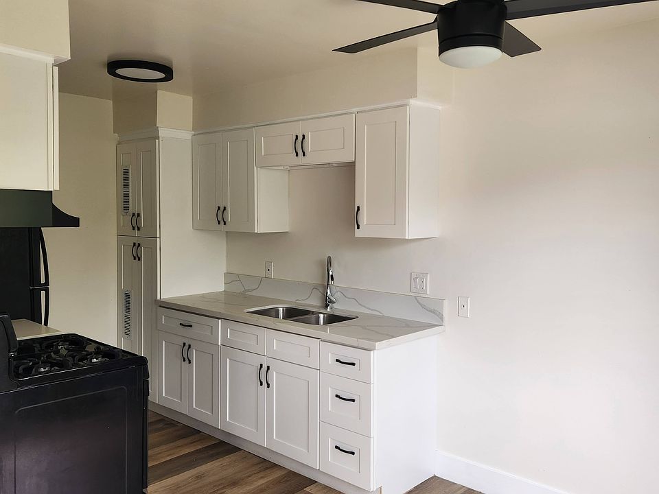 Renovated kitchen with white shaker style cabinets, soft close hinges, quartz counters, black appliances. Ceiling fan in the dining area and bedrooms.