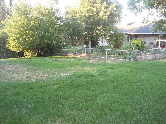 Fenced backyard with sprinkler system.