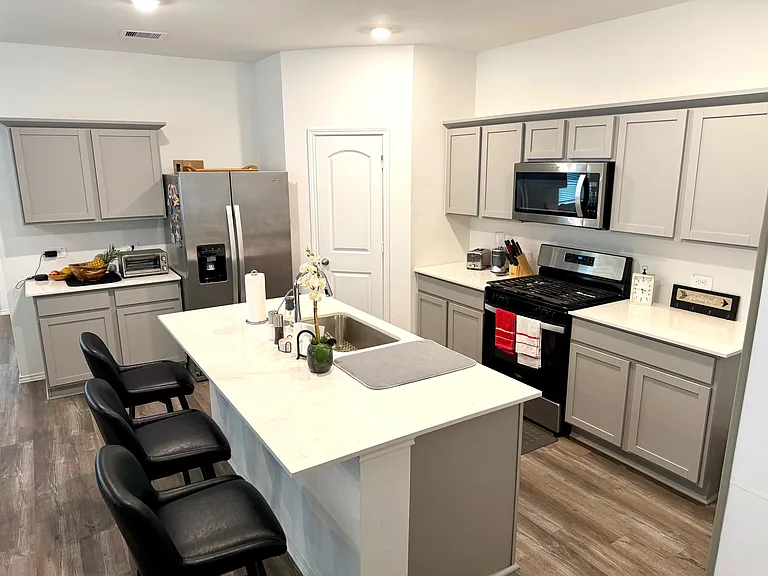 Spacious kitchen with a large island, ample cabinet storage, and stainless-steel appliances for everyday cooking.