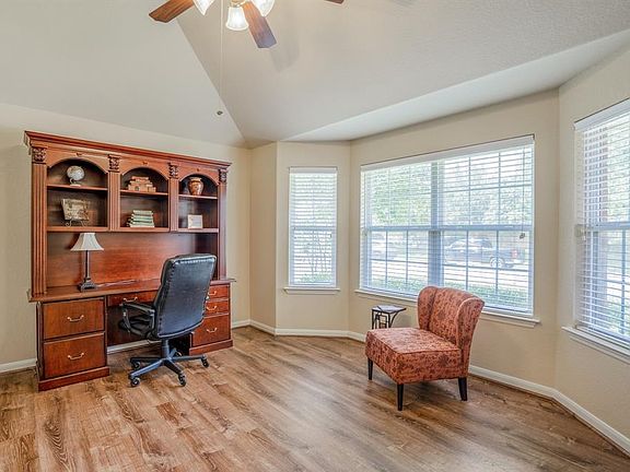The large study is at the front of the home, has an angle ceiling, lighted ceiling fan, beautiful flooring and lots of natural light streams into the room through those lovely large windows.