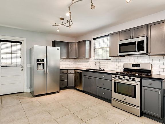 Stainless kitchen appliances with leathered granite, tile flooring and good cabinet space