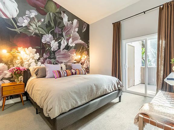 Spacious master bedroom with West Elm furniture and 70" Sony Smart TV