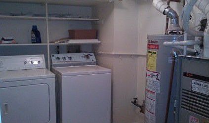 Laundry Room with new washer, dryer and lots of shelving.