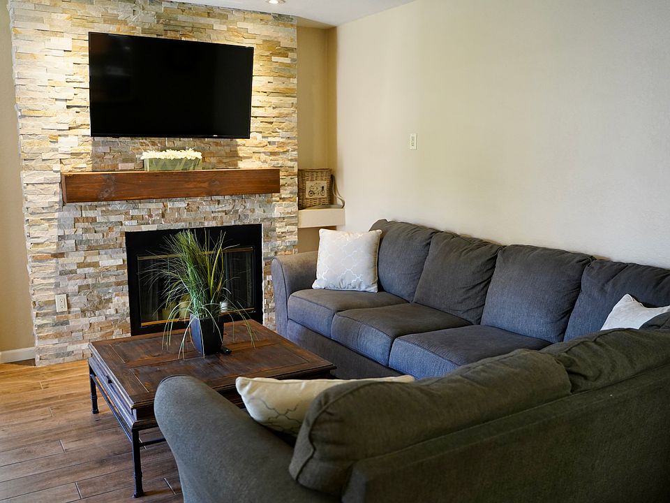 Living Room with Stacked Stone Fireplace and TV