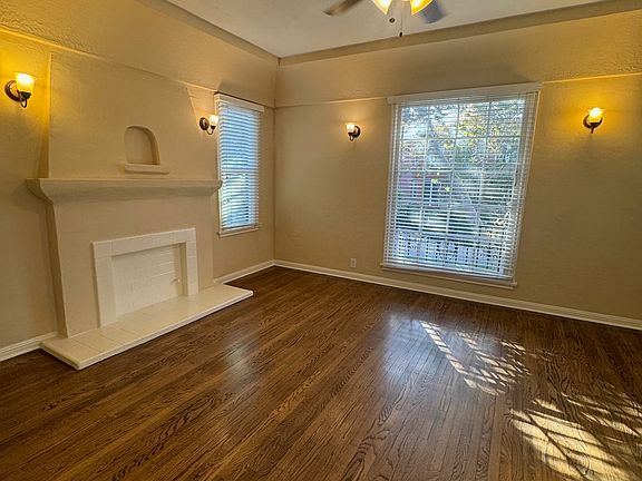 Unit 5 living room with faux fireplace and large window facing Almont Drive.
