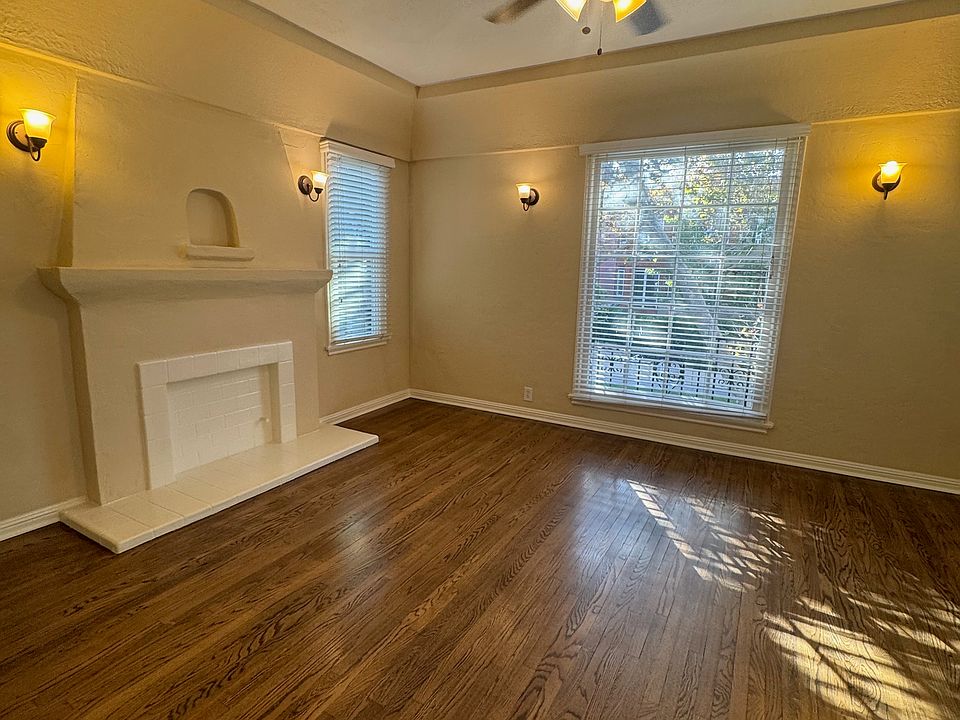 Unit 5 living room with faux fireplace and large window facing Almont Drive.
